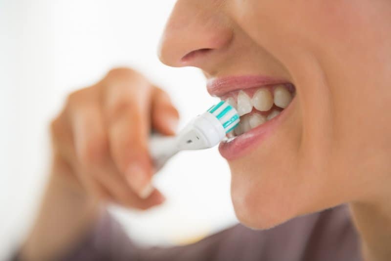 Closeup of woman brushing her teeth